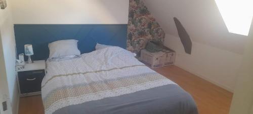 Schlafzimmer mit einem Bett mit blauem Kopfteil in der Unterkunft Chambres à louer in La Suze-sur-Sarthe