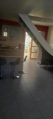 eine Küche mit einem Tisch und Stühlen sowie eine Treppe in der Unterkunft Chambres à louer in La Suze-sur-Sarthe