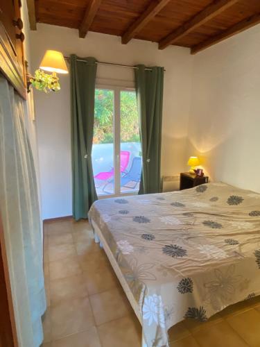 1 dormitorio con cama y ventana en Casa Lova, en Propriano