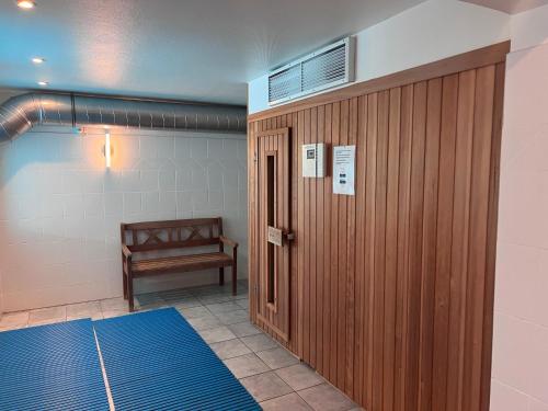 a locker room with a wooden door and a bench at Nordland Appartements - Wohnung Amrum in Wyk auf Föhr