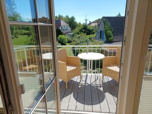 mit Blick auf einen Balkon mit einem Tisch und Stühlen in der Unterkunft An den Boddenwiesen I in Wustrow