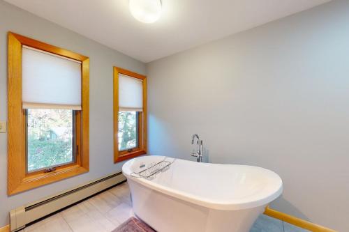 a white bath tub in a bathroom with two windows at Broadlake in Thayer Beach
