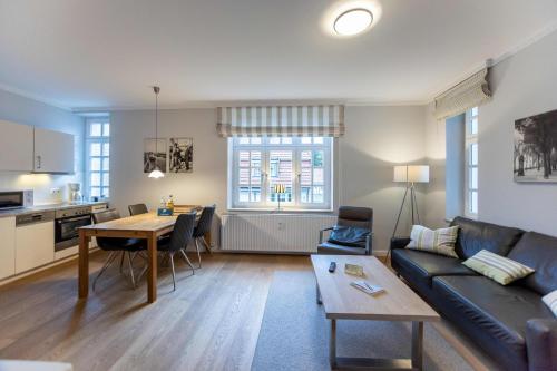 ein Wohnzimmer mit einem Sofa und einem Tisch in der Unterkunft Villa Friedericia in Wyk auf Föhr