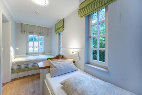 a bedroom with two beds and two windows at Villa Friedericia in Wyk auf Föhr
