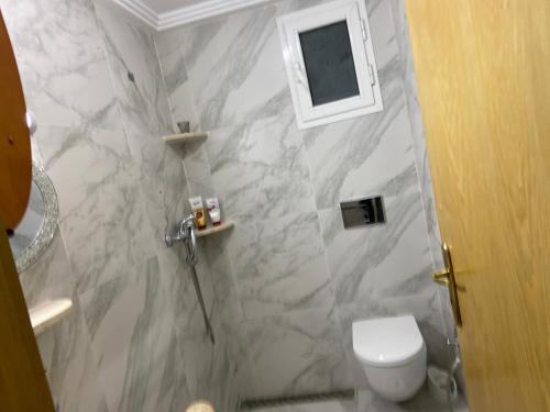 La salle de bains est pourvue de toilettes et d'un mur en marbre. dans l'établissement La mer carrément à vos pieds, à Hammamet