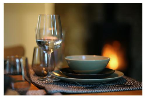 un tavolo con una ciotola e un bicchiere di vino di Poilsio namelis 