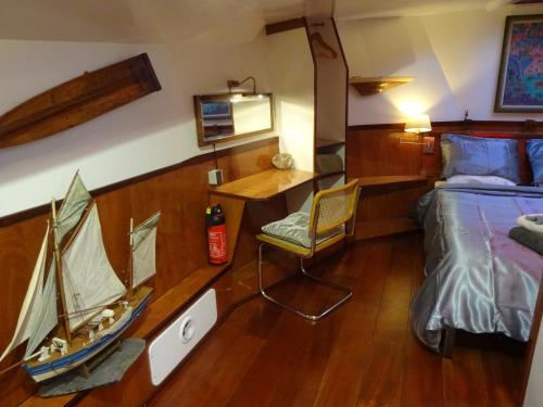 アムステルダムにあるAnna Houseboatのベッドルーム1室(ベッド1台付)、壁に小さなボートが備わります。