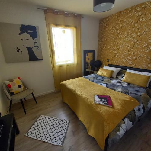 a bedroom with a bed and a chair and a window at A L'OMBRE DES 2 TILLEULS maison d'hôtes adults only in Sainte-Pazanne