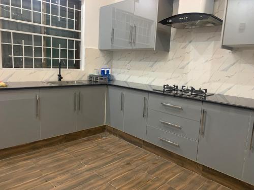 a kitchen with white cabinets and a sink at Bahria Residency in Rawalpindi