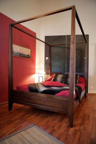 a bedroom with a canopy bed with red walls at La Villa Blanche in Marseille