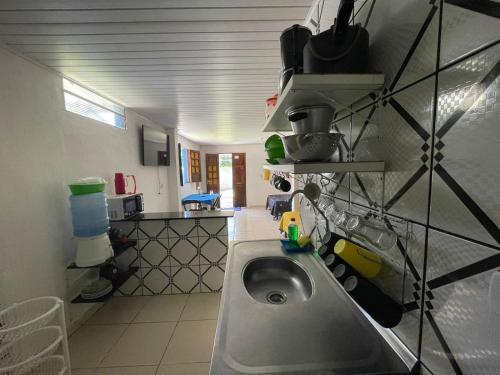 a kitchen with a stainless steel sink in a room at Casa na Orla - Praia de Gaibu! in Cabo de Santo Agostinho