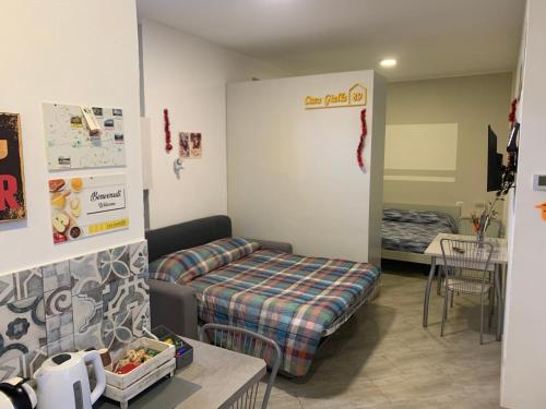 Cette chambre comprend un canapé, un lit et une table. dans l'établissement Casa Gialla 89, à Garbagnate Milanese