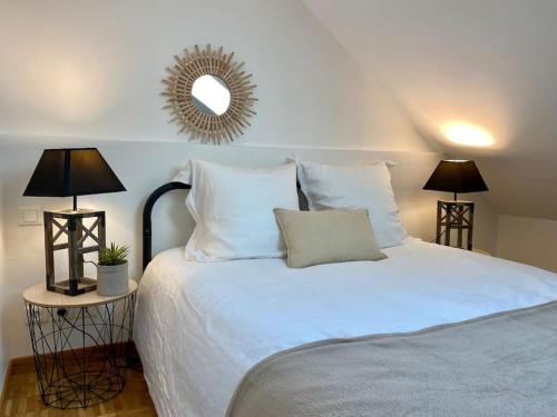 a bedroom with a white bed with two lamps and a mirror at Le Cosy Troyen secteur calme 4 personnes parking privé in Troyes