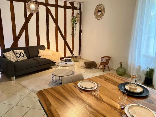 a living room with a table and a couch at Le Cosy Troyen secteur calme 4 personnes parking privé in Troyes