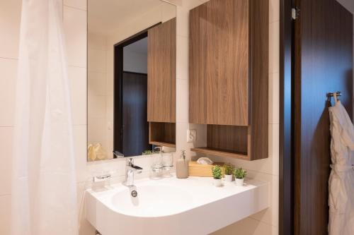 a bathroom with a white sink and a mirror at Senevita Dorfmatt Ferienwohnungen und Apartments in Münsingen