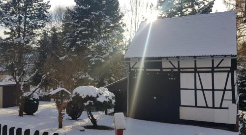 a snow covered building with the sun shining on it at Ferienwohnung MAI in Glauchau