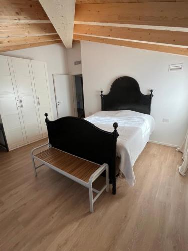a bedroom with a black bed and a bench at CASA PAOLA in Sala Bolognese