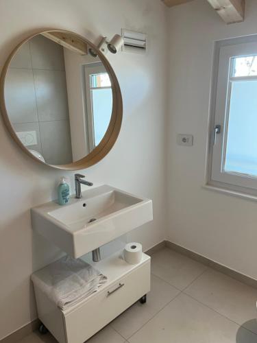 a white bathroom with a sink and a mirror at CASA PAOLA in Sala Bolognese