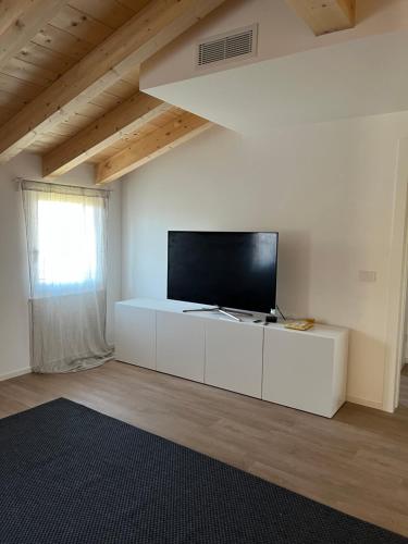 a living room with a flat screen tv on a white wall at CASA PAOLA in Sala Bolognese