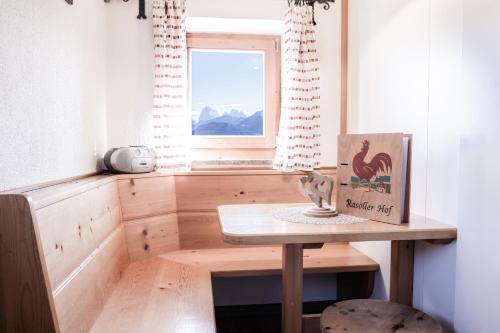 Una pequeña mesa en una habitación con ventana en Rasöller Hof, en Villandro