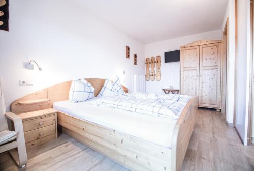 um quarto com uma grande cama de madeira num quarto em Rasöller Hof em Villandro
