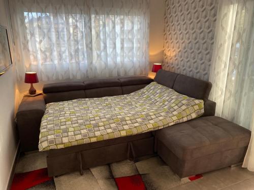 een bed en een bank in een kamer met een raam bij Relax and enjoy with a view of El Teide and sea in Puerto de Santiago