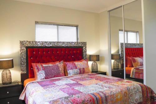 1 dormitorio con 1 cama grande y espejo en Top End Marvel -Darwin's Premier 3-BR Luxury Apt en Darwin