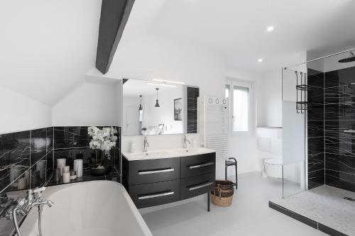 uma casa de banho com uma banheira, um lavatório e um chuveiro em Au Domaine Cru em Savignies