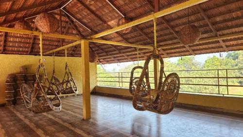 a room with chairs hanging from a ceiling at MAP RESORT in Alibaug