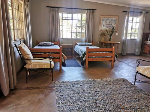 a living room with two beds and a chair at Rustic Country Cottage in White River