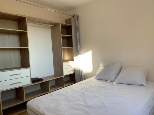 a bedroom with a white bed and a mirror at Spacieux F3 Port Leucate in Leucate