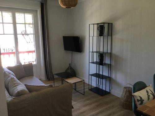 a living room with a couch and a television at APPARTEMENT REFAIT A NEUF, IDEALEMENT SITUÉ in La Baule