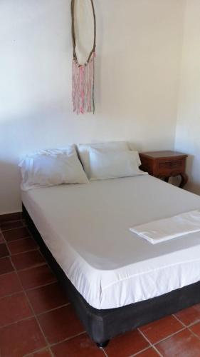 a bed in a room with a white bedsheet at Casa chill out in Minca