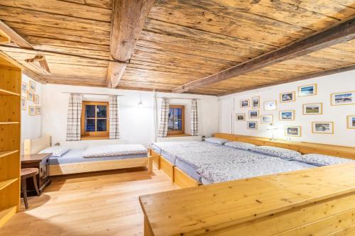 two beds in a room with wooden ceilings at Ferienhaus Alte Mühle Hohentauern in Hohentauern