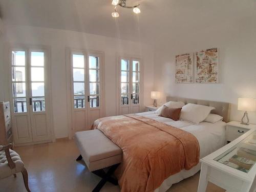 a white bedroom with a large bed and windows at Villacana Playa Silvia in Estepona