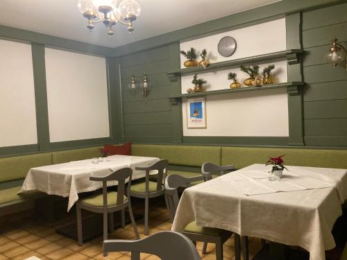 マリア・アルム・アム・シュタイナーネン・メアーにあるRosi`sのテーブル2台と椅子(白いテーブルクロス付)が備わるレストラン