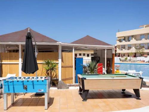 two pool tables and an umbrella on a patio at Casa de Simo · Sol, Relax y diversión in Adeje