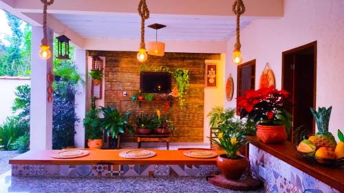 una habitación con una mesa con frutas y plantas en Pérola de Paraty 03 com Piscina, en Paraty