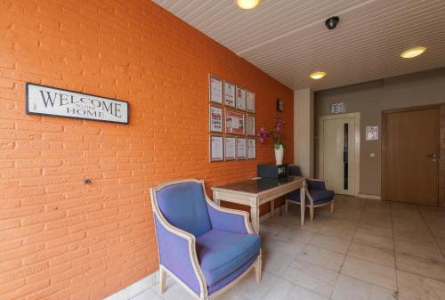 a lobby with chairs and a table and a welcome home sign at Budget Flats Antwerp in Antwerp