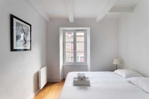 um quarto branco com uma cama e uma janela em Le Phare de la Fenêtre em Cancale