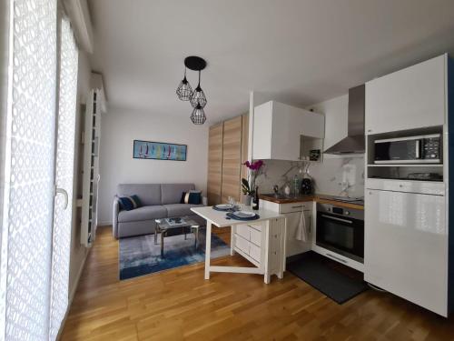a kitchen and living room with a table and a couch at Beau studio cosy entre Paris et Disneyland in Villiers-sur-Marne