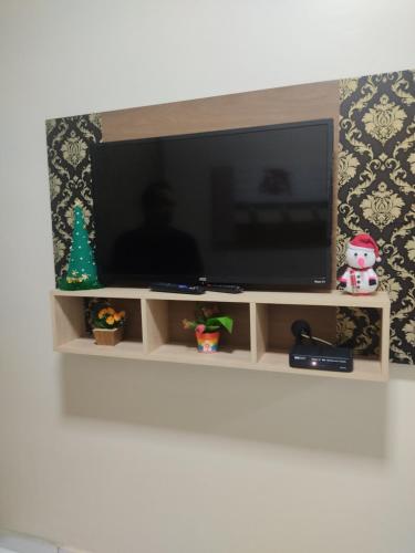 a flat screen tv sitting on top of a shelf at Dunas Residence casa 04- Lençois Maranhense in Santo Amaro