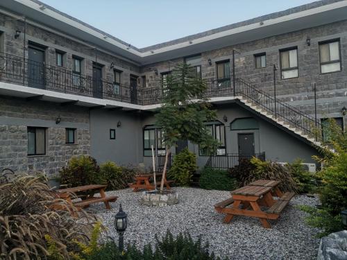 a courtyard of a building with picnic tables and stairs at נופש מול הכנרת Vacation in front of the Sea Galilee in Tiberias