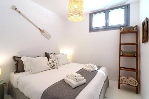 a bedroom with a white bed with towels on it at The Nine Graces - Kastraki Villas with Private Swimming Pool in Kastraki Naxou