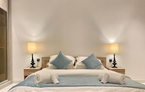 a bedroom with a large bed with blue pillows at Spacious new 2 bedroom Apt-in amazing location B6 in Riyadh