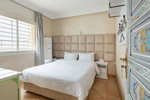 a bedroom with a white bed and a window at La villa des corsaires, vue panoramique sur Rabat in Sale