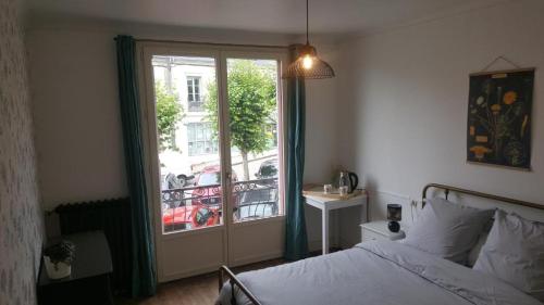 um quarto com uma cama e uma janela com uma varanda em Chambres d'hôtes au centre de Guémené-sur-Scorff em Guéméné-sur-Scorff
