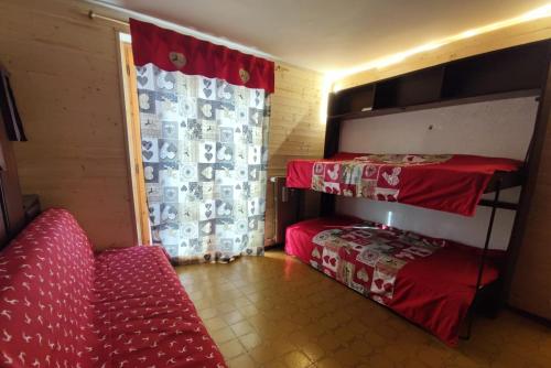 a room with two bunk beds and a couch at CASA MIRTILLO sci ai piedi in Prato Nevoso