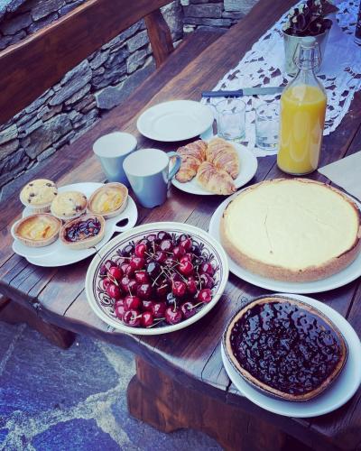 a wooden table topped with plates of fruit and pies at CORTE DI CAVNE' in Miazzina
