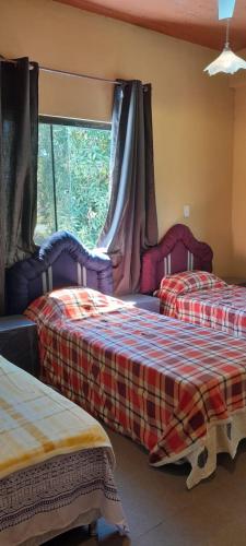 a room with two beds and a window at Hospedaje San Miguel in Luque